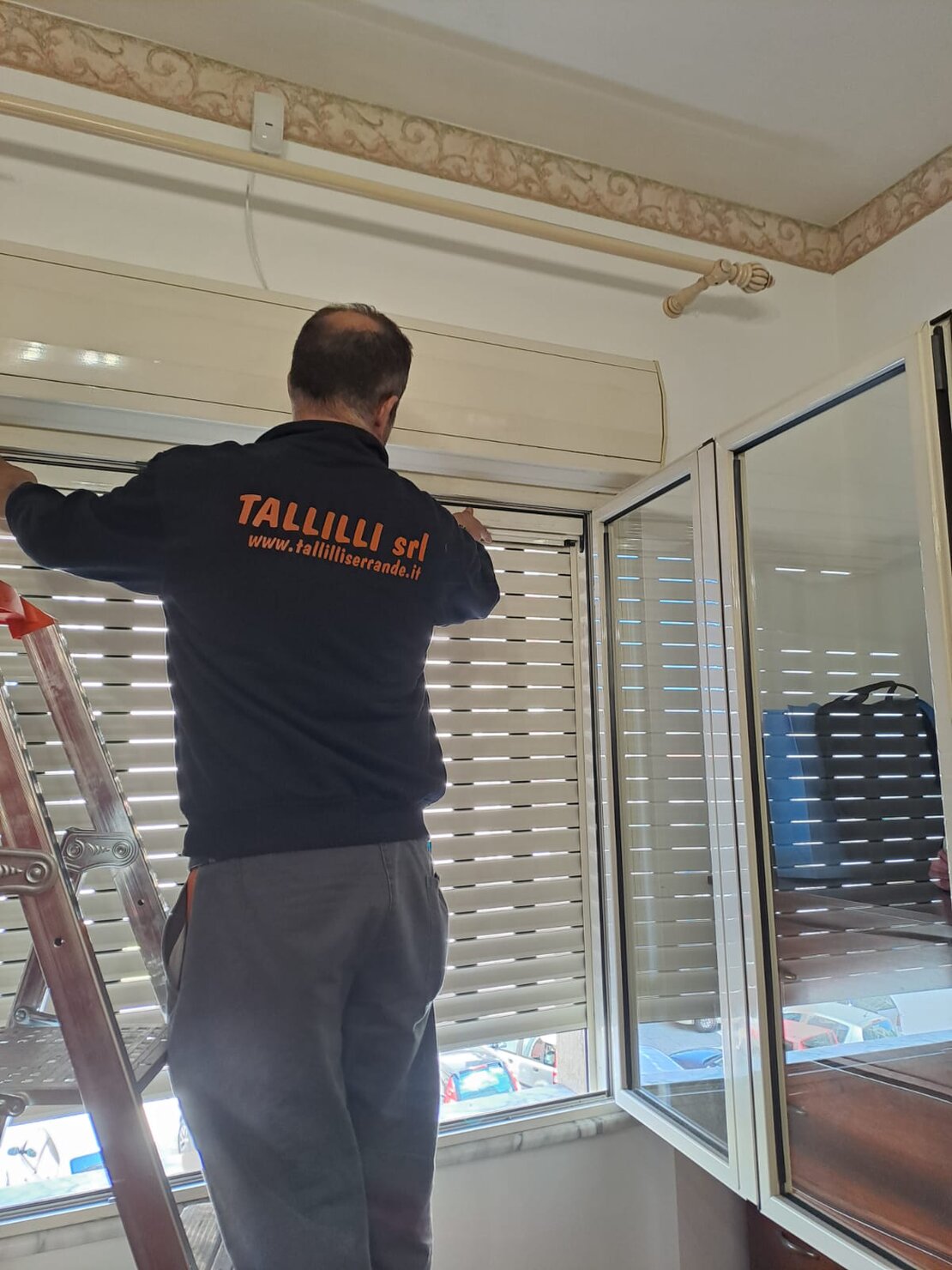 Tecnico che esegue manutenzione su serranda