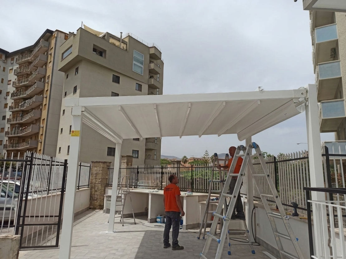 Tenda da sole a bracci estensibili installata su balcone di appartamento
