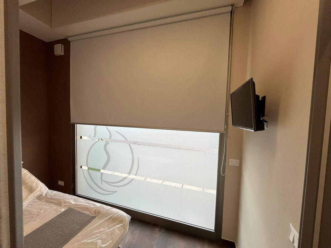 Tende a rullo installate su grandi finestre di un soggiorno