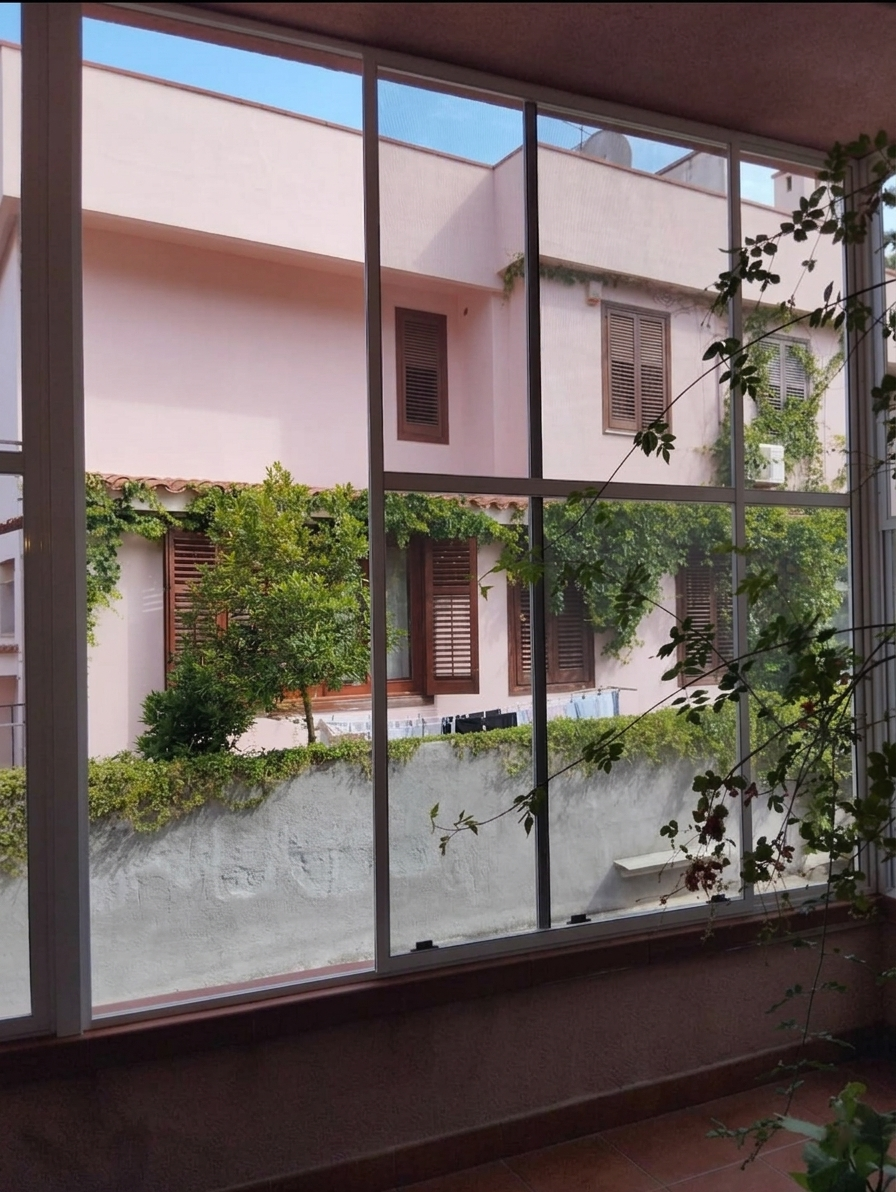 Zanzariera scorrevole su grande portafinestra verso il balcone