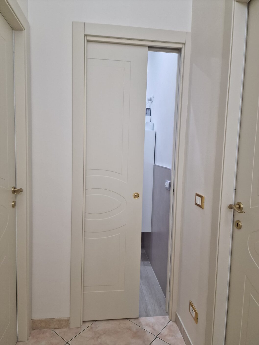 Porta scorrevole interna in vetro satinato che separa zona giorno e cucina