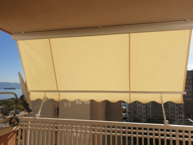 Balcone con tenda da sole esterna che crea ombra sul terrazzo