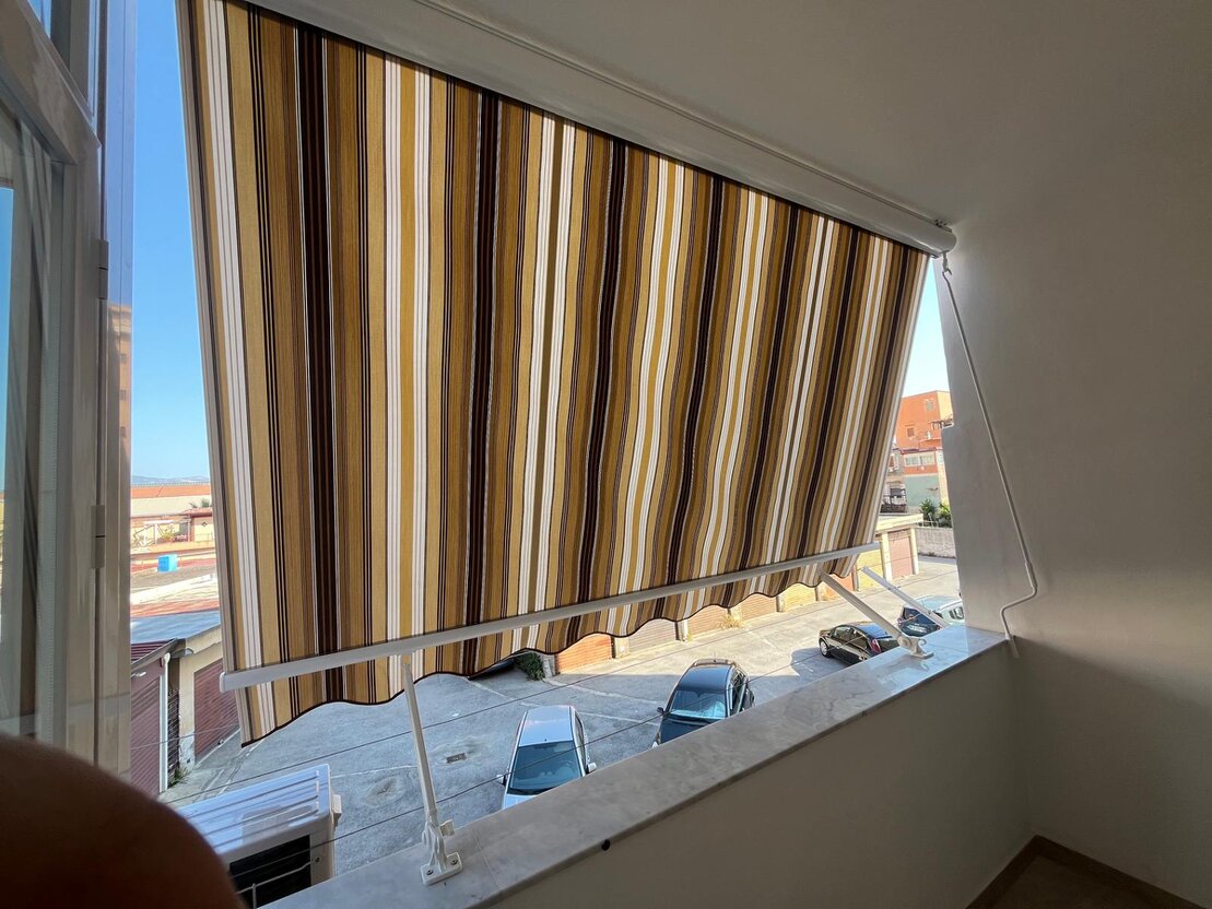 Tenda a caduta verticale installata su balcone chiuso a loggia